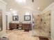Large bathroom featuring dual vanities, stand alone shower with glass doors, and tile floors at 1444 Pelican Bay Trl, Winter Park, FL 32792