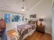 Bedroom features a queen bed and beautiful view of the lake from the large picture window at 1444 Pelican Bay Trl, Winter Park, FL 32792