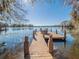 Charming wooden dock with chairs, offering serene water views under a clear blue sky at 1444 Pelican Bay Trl, Winter Park, FL 32792
