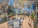 Waterfront dock featuring an outdoor dining set, beautiful trees, and a distant view of the home at 1444 Pelican Bay Trl, Winter Park, FL 32792