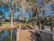 Dock featuring a table and chairs, with views of the home surrounded by trees and peaceful water at 1444 Pelican Bay Trl, Winter Park, FL 32792