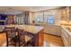 Open kitchen view featuring stainless appliances, granite counters, large island with seating, hardwood floors, and water view at 1444 Pelican Bay Trl, Winter Park, FL 32792