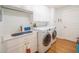 Convenient laundry room features side by side washer and dryer, sink, folding counter and storage cabinets at 1444 Pelican Bay Trl, Winter Park, FL 32792