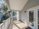 Covered patio offering serene views of the lake through trees, features white railing and double doors at 1444 Pelican Bay Trl, Winter Park, FL 32792