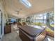Open-air patio boasts lake views, hot tub, outdoor kitchen, and comfortable lounging spaces at 1444 Pelican Bay Trl, Winter Park, FL 32792