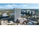 Striking aerial view of a modern high-rise residential building with a rooftop pool overlooking a scenic lake and city at 150 E Robinson St # 219, Orlando, FL 32801