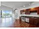 Open living space with stainless steel kitchen, hardwood floors, and spiral staircase at 150 E Robinson St # 219, Orlando, FL 32801