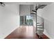 Open living space with hardwood floors, balcony, and spiral staircase at 150 E Robinson St # 219, Orlando, FL 32801