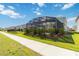 Well-kept backyard showcasing a screened pool enclosure, landscaping, and a paved path for easy access at 1565 Leaf Ln, Kissimmee, FL 34744