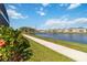 Scenic backyard view of pond and walkway lined with trees in a well-maintained community at 1565 Leaf Ln, Kissimmee, FL 34744