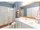 Bathroom featuring glass enclosed shower, white vanity, and a large mirror at 1565 Leaf Ln, Kissimmee, FL 34744
