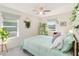 Airy bedroom with a mint green bedspread, lots of plants, and natural light streaming through the windows at 1565 Leaf Ln, Kissimmee, FL 34744