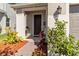 Welcoming front entryway with a dark wood door, a lantern, and mature landscaping at 1565 Leaf Ln, Kissimmee, FL 34744