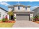 Charming two-story home featuring a well-manicured lawn, paver driveway, and neutral color palette at 1565 Leaf Ln, Kissimmee, FL 34744