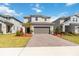 Attractive two-story home showcasing a paver driveway, manicured lawn, and modern architectural details at 1565 Leaf Ln, Kissimmee, FL 34744