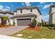 Inviting two-story home featuring a paver driveway, attached garage, and neatly landscaped front yard at 1565 Leaf Ln, Kissimmee, FL 34744