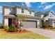 Beautiful two-story home with a well-kept lawn, modern design elements, and professional landscaping at 1565 Leaf Ln, Kissimmee, FL 34744
