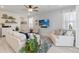 Spacious living room with a ceiling fan, tv, plush sofas, and views of backyard at 1565 Leaf Ln, Kissimmee, FL 34744
