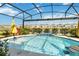 Gorgeous screened pool with sun umbrella, waterfall feature and clear water creating a serene oasis at 1565 Leaf Ln, Kissimmee, FL 34744