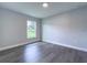 Bright bedroom with wood-look flooring, neutral walls, and a large window overlooking the lawn at 1706 3Rd Ave, Deland, FL 32724