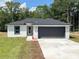 Charming single-Gathering home with a two-car garage, lush lawn, and a sleek, modern design at 1706 3Rd Ave, Deland, FL 32724
