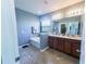 Bathroom featuring double sink vanity with modern fixtures, soaking tub, and tiled floor at 17459 Chateau Pine Way, Clermont, FL 34711