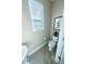 Cozy powder room featuring a toilet, a window, and a small pedestal sink at 17459 Chateau Pine Way, Clermont, FL 34711