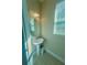 Powder room offers a pedestal sink, decorative mirror, and natural light at 17459 Chateau Pine Way, Clermont, FL 34711