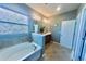Bathroom featuring a garden tub, tiled floors, and large vanity with an oversized mirror at 17459 Chateau Pine Way, Clermont, FL 34711