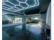 Spacious garage featuring epoxy floors, storage cabinets, and a high-tech ceiling light grid at 17459 Chateau Pine Way, Clermont, FL 34711