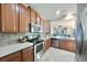 Eat-in kitchen featuring a stainless steel oven, microwave, and dark wood cabinets; and an open view to the living room at 17459 Chateau Pine Way, Clermont, FL 34711