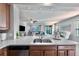The kitchen features a stainless dishwasher and sink with granite counters, and wood cabinets at 17459 Chateau Pine Way, Clermont, FL 34711