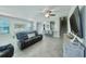 An open-concept living room featuring a ceiling fan, tile floors, and a view of the dining room and kitchen at 17459 Chateau Pine Way, Clermont, FL 34711