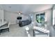 Open-concept living room features tile flooring, a ceiling fan, and sliding glass doors to the screened-in patio at 17459 Chateau Pine Way, Clermont, FL 34711