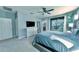 Bright main bedroom featuring a ceiling fan, balcony access, and a large dresser with a television at 17459 Chateau Pine Way, Clermont, FL 34711
