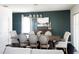 Dining room featuring a long wooden table, neutral chairs, modern chandelier, and dark green accent wall at 1943 Fountains Dr, Kissimmee, FL 34744