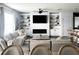 Open living room with a comfortable sectional, built-in shelving, a modern fireplace, and contemporary decor at 1943 Fountains Dr, Kissimmee, FL 34744
