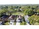 Aerial view showcases the homes in a neighborhood, surrounded by lush greenery and mature trees near a golf course at 2316 Paulette Dr, Haines City, FL 33844