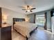 Relaxing bedroom featuring a ceiling fan, a large window viewing the pool, and neutral decor at 2316 Paulette Dr, Haines City, FL 33844