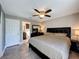 Bedroom featuring a ceiling fan, ensuite bathroom, black furniture, and neutral decor at 2316 Paulette Dr, Haines City, FL 33844
