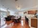 Dining room with wood floors, a ceiling fan, and a view of the living room and sliding glass doors to the patio at 2316 Paulette Dr, Haines City, FL 33844
