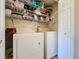 Functional laundry area with washer, dryer, and shelving for organized storage solutions, accessed by white doors at 2316 Paulette Dr, Haines City, FL 33844