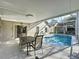 Covered patio with a dining table overlooking a screened pool, ideal for outdoor meals and relaxation at 2316 Paulette Dr, Haines City, FL 33844