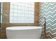 Close up of the bathtub with tile accents and glass block window at 2515 Ridgewind Way, Windermere, FL 34786
