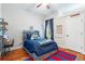 Cozy bedroom with a blue bed, hardwood floors, a ceiling fan, and a stylish desk area at 2515 Ridgewind Way, Windermere, FL 34786