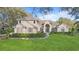 Stately tan two-story home featuring a manicured front lawn and elegant architectural details at 2515 Ridgewind Way, Windermere, FL 34786