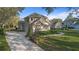 A beautifully landscaped two-story home features a curved driveway, well-maintained lawn and mature shrubbery at 2515 Ridgewind Way, Windermere, FL 34786