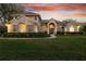 Stately two-story home with manicured landscaping and a welcoming entrance, showcasing elegance and curb appeal at twilight at 2515 Ridgewind Way, Windermere, FL 34786