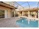 A pool and spa area surrounded by brick pavers with a summer kitchen and covered patio with outdoor furniture at 2515 Ridgewind Way, Windermere, FL 34786