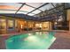A stunning screened-in pool with a spa and brick paver deck surrounded by the home's exterior at 2515 Ridgewind Way, Windermere, FL 34786
